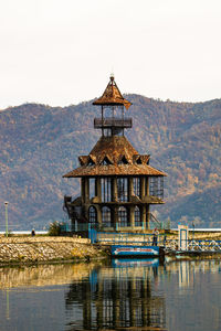 Built structure on lake by building against sky