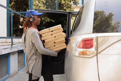 Side view of woman sitting on car