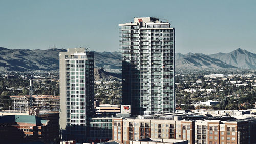 Buildings in city against clear sky