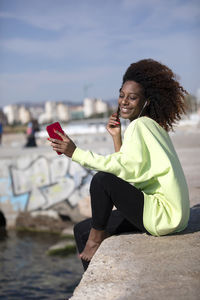 Portrait of young woman sitting on rock