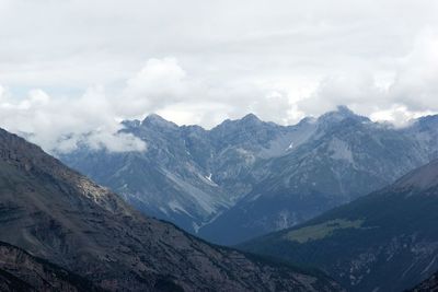 Scenic view of mountain range against cloudy sky