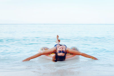 Portrait of young woman in sea against sky