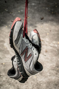 Close-up of shoes hanging by shoelace