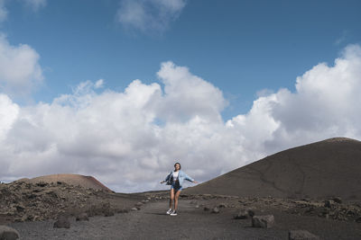 Woman with arms outstretched spinning while standing on footpath at volcano el cuervo, lanzarote, spain