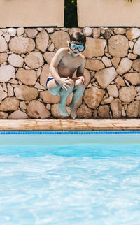 Little child jumping into a pool