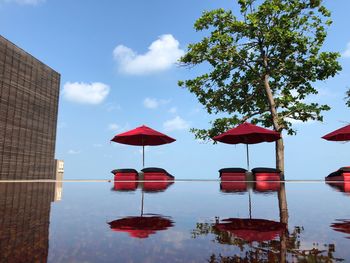 Flag by swimming pool by lake against sky