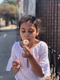 Girl blowing dandelion in city