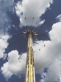 Low angle view of chain swing ride against sky