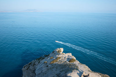 High angle view of rocks by sea against sky