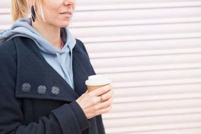 Midsection of woman holding coffee cup