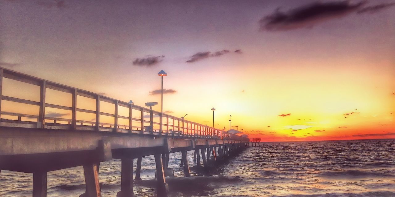 sea, water, sunset, horizon over water, pier, sky, railing, beach, built structure, scenics, tranquility, beauty in nature, nature, shore, tranquil scene, architecture, idyllic, orange color, outdoors, wave