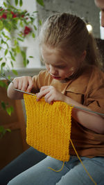 Girl crocheting at home