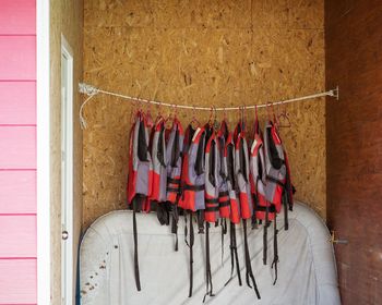 The life jacket hanging on a rope on a wooden wall.