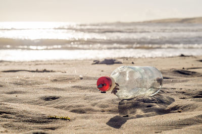 Close-up of bottle on beach