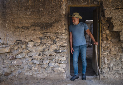 Adult man in cowboy hat and jean in a rural area