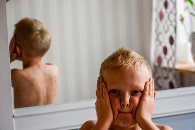 Portrait of shirtless boy in bathroom