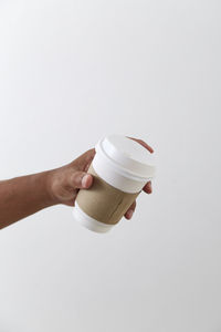 Midsection of person holding drink against white background