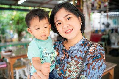 Portrait of mother holding son at home