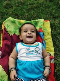 High angle view of baby lying on grass