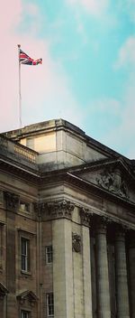Low angle view of flag against built structure