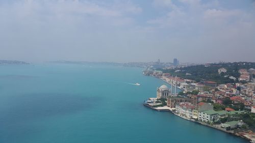 High angle view of city by sea against sky