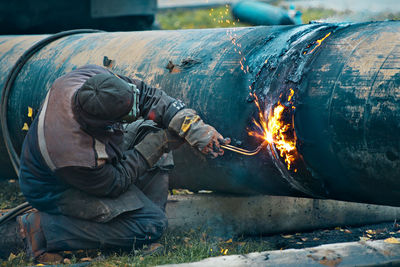 Low angle view of man working on metal