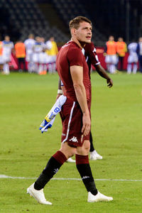 Full length of teenage boy playing soccer on field