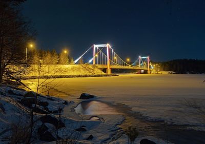 View of suspension bridge during winter at night