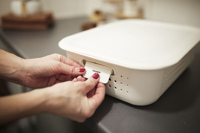 Woman's hands putting label on basket