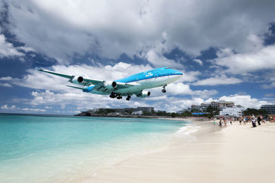 Airplane flying over sea against sky