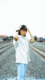 Young woman looking away while standing on land against clear sky