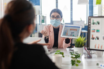 Portrait of businesswoman wearing mask at office