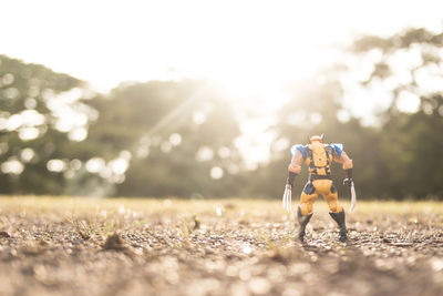 Surface level of man on field against sky on sunny day