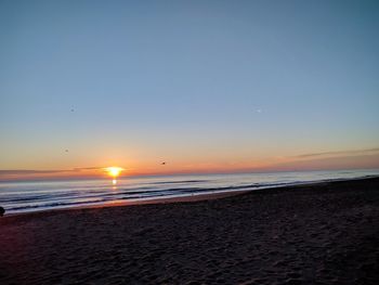 Scenic view of sea against clear sky during sunset