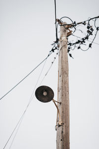 Low angle view of telephone pole against sky