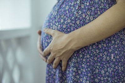 Close-up of woman hand on purple at home