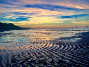 Scenic view of beach against sky during sunset