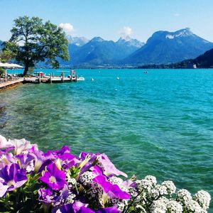 Scenic view of sea and mountains against blue sky