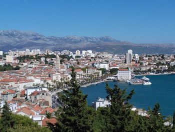 High angle view of townscape by sea against sky