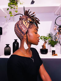 Side view of young woman sitting at home