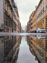 Reflection of buildings in puddle on street