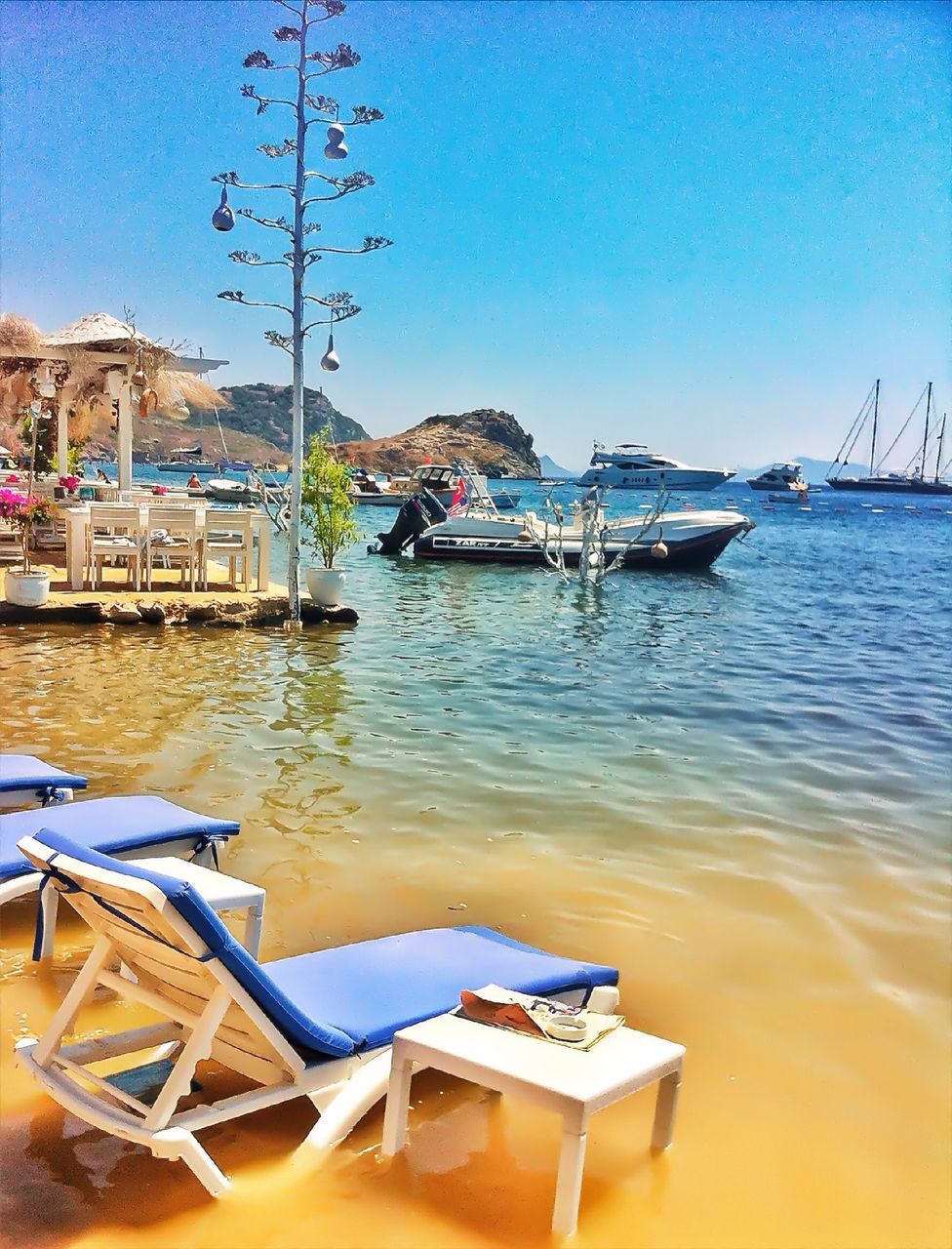 nautical vessel, transportation, boat, water, moored, mode of transport, clear sky, sea, blue, tranquility, copy space, tranquil scene, nature, travel, sunlight, sky, sailboat, outdoors, day, tree