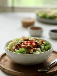 Close-up view of indonesian spicy salad, topped with peanut sauce on the table.