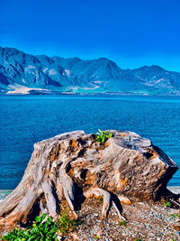 Scenic view of sea and mountains against blue sky