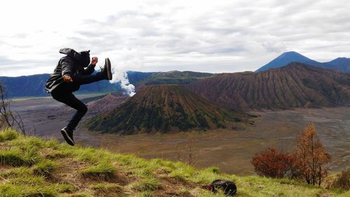 Full length of photographer on land against sky