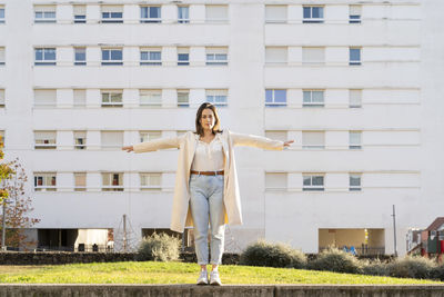 Full length of woman standing against building in city