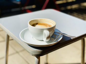 Close-up of white coffee on gray table in bright sunlight