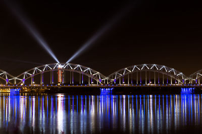 Illuminated bridge against sky at night