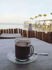 Close-up of coffee on table against sea