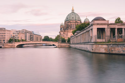 Arch bridge over river against buildings in city